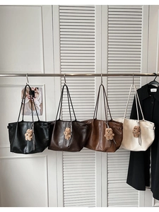 Close-up of tote bags in four colors with cute plush bear charms and shoulder straps