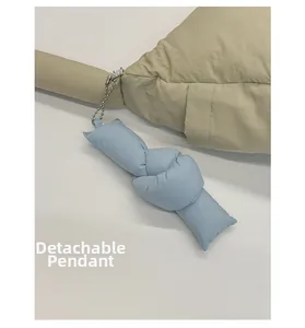 Dettaglio di un ciondolo a nodo imbottito celeste rimovibile su borsa in nylon beige