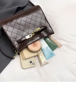 Top view of spacious interior in quilted dark brown bag with golden clasp and hardware