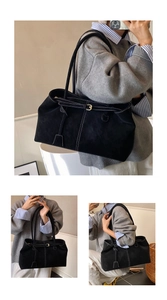 Detail view of large black suede tote bag with contrast stitching and adjustable strap