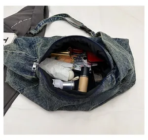 Detailed interior of a large denim crossbody bag showing ample space for daily essentials