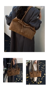 Detail of a large brown suede tote bag with decorative strap for casual daily commuting