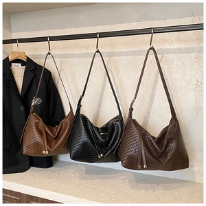 Gros plan détaillé de sacs hobo en cuir tressé en noir, marron clair et marron foncé