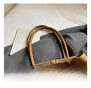 Détail du sac cabas en cuir souple marron avec boucles et fines anses élégantes