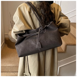 Deep brown matte leather tote bag with white contrast stitching and tie detail