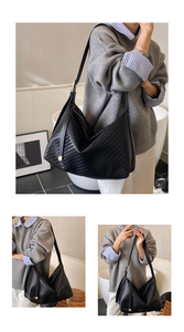 Gros plan détaillé d'un grand sac hobo noir en cuir tressé avec boucle métallique chic