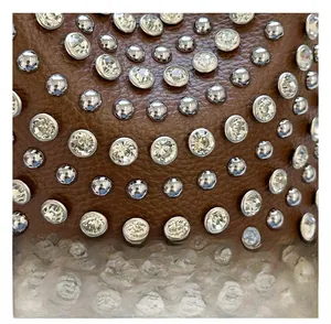 Detail einer dunkelbraunen Ledertasche mit funkelnden Strasssteinen und Silbernieten