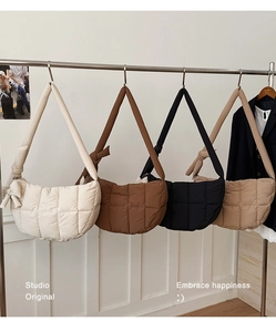 Détail de sacs matelassés en beige, marron et noir avec un nœud décoratif sur le côté