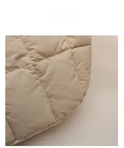 Gros plan sur la texture matelassée beige d'un sac à main d'hiver en coton doux