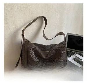 Détail du sac hobo tressé marron foncé avec bandoulière réglable et texture en cuir