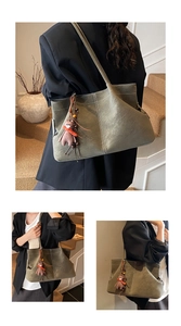 Detail of suede tote bag with contrast stitching and a cute bear plush keychain