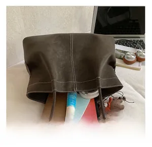 Detailed interior capacity of large suede tote bag with daily essentials inside