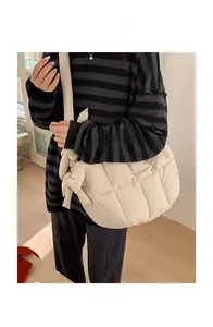Gros plan du sac bandoulière matelassé beige avec nœud décoratif et coutures à carreaux