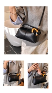 Détails du sac à main en cuir grainé noir avec anneau doré et bandoulière réglable