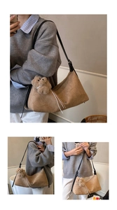 Detail view of khaki pleated tote bag with a cute bear pendant and long black strap