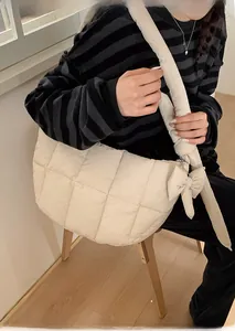 Détail du sac bandoulière matelassé avec des nœuds décoratifs et un rembourrage doux