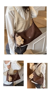 Detail view of dark brown textured tote bag featuring a cute teddy bear charm