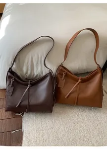 Détail des grands sacs cabas en cuir mat marron foncé et caramel avec nœud coulissant décoratif