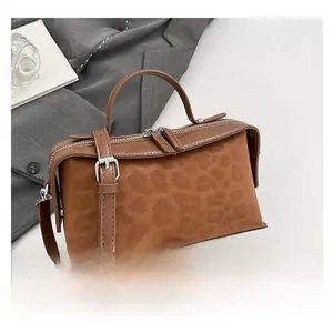 Detail of leopard print crossbody bag with metal dual-zip closure and top handle