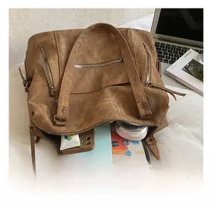 Vue intérieure montrant la grande capacité du sac fourre-tout marron avec divers articles