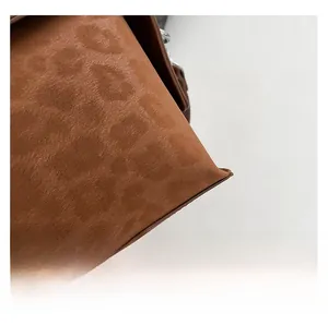Detailed macro view of brown leopard print faux suede fabric with precise corner stitching