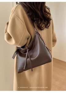 Détail du grand sac cabas marron foncé montrant la forme hobo et le cuir lisse