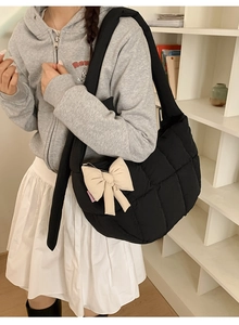 Détail du grand sac cabas noir matelassé avec un charmant nœud crème sur l'épaule