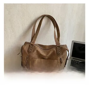 Détails du sac fourre-tout en cuir marron vintage avec poches zippées et rivets métalliques