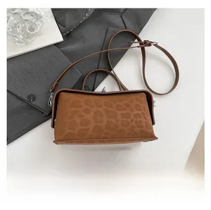 Leopard print handbag detail showing scale with a smartphone on a minimalist desk
