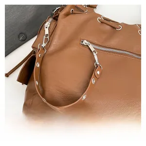 Close-up of brown litchi pattern leather with silver zipper and hardware details