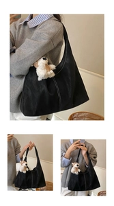 Close-up of black tote bag with white contrast stitching and cute plush bear charm