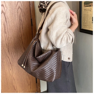 Détail du sac hobo marron foncé avec texture tressée et long gland décoratif