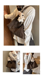 Detail of dark brown tote bag with contrast white stitching and plush bear charm