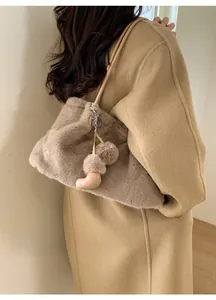 Détail du sac seau en fausse fourrure pelucheuse avec pompon et pendentif bottes