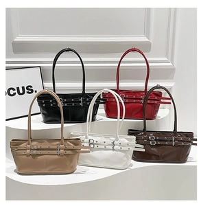 Detail of multi-color patent leather tote bags with metal buckles and pleat design