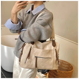 Détail du sac cabas en toile vintage avec poches multiples et tirettes en cuir brun