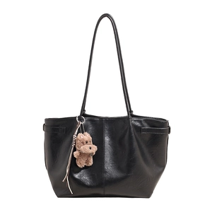 Minimalist black PU leather tote bag with stylish plush puppy charm and long shoulder straps