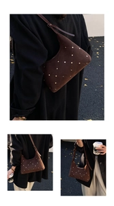 Detail of brown suede baguette bag with golden studs and diamond quilted pattern