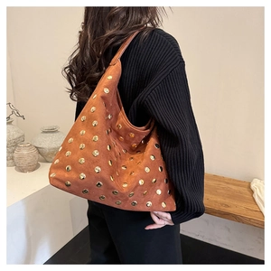 Detail of brown suede hobo bag featuring decorative gold round rivets and a large capacity