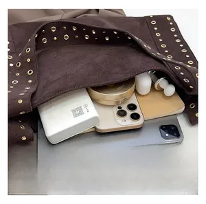 Detail view of large capacity interior for brown suede tote with metal rivets