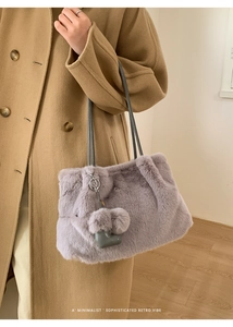 Detail der lavendelfarbenen Kunstfelltasche mit Herzanhänger und grauem Schultergurt