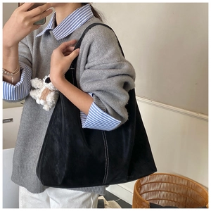 Large black suede tote bag with white stitching and a cute teddy bear charm detail