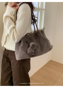 Detailaufnahme der flauschigen Kunstpelz-Beuteltasche mit Herzanhänger in Kaffeegrau