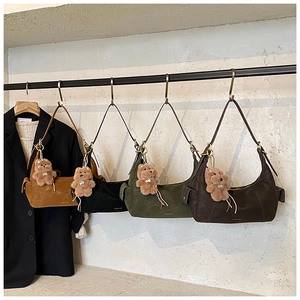 Detail of suede crossbody bags in four colors with cute plush bear charms and zip top
