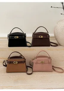 Detail of four matte suede crossbody bags in black and brown with vintage gold hardware