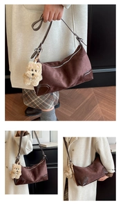 Detail of dark brown suede hobo bag with leather trim and plush puppy pendant