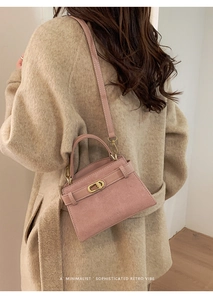 Pink suede retro handbag shown styled with a beige coat for a minimalist look