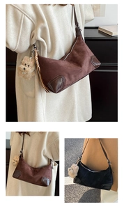 Detail of vintage patchwork shoulder bag with matte suede texture and plush dog charm