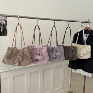 Dettaglio di borse a secchiello in peluche in cinque colori con ciondoli a cuore