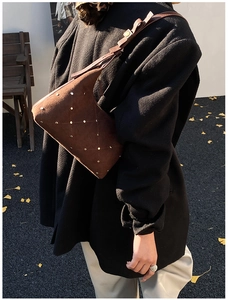 Detail of vintage brown matte leather shoulder bag with gold rivet stud patterns